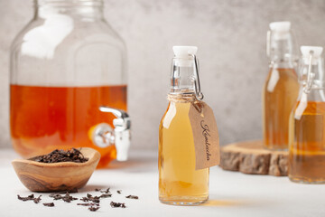 Obraz na płótnie Canvas Refreshing filtered kombucha tea in a glass bottle and a jar. Healthy drink