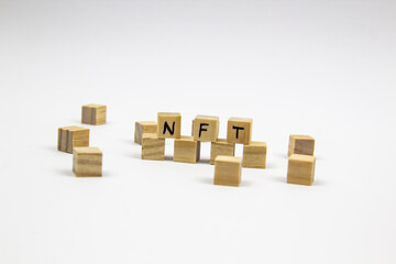 Word NFT (non fungible token) written on the wood cubes on white  background. Non-fungible tokens  concept NFT.