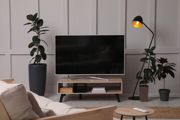 Stylish room interior with TV on wooden cabinet