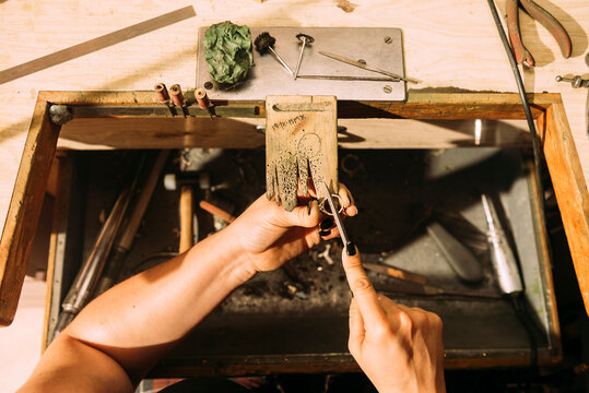 Female jeweler shaping ring with rasp at workshop