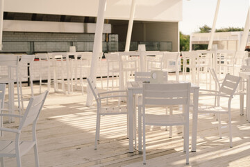 White table and chairs in cafe outdoors. Street cozy restaurant