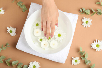 Obraz na płótnie Canvas Concept of hand care on beige background with flowers