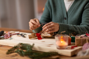 winter holidays and hobby concept - close up of woman with box and rope packing christmas gift or making advent calendar at home