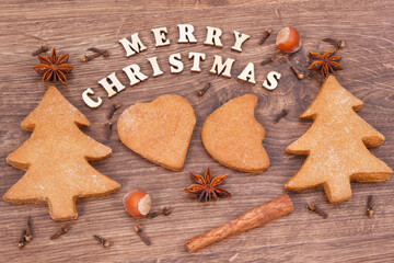 Fresh baked gingerbreads, inscription Merry Christmas and spices for baking