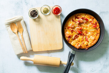Pizza in pan,Fresh raw pizza with mushrooms, cherry tomatoes , Basil and Parmesan in a round pan on a white background with copy space. Homemade pizza before baking 