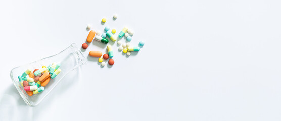 Pills and science experiments on white background, White medicine capsules spill out from transparent bottle,Prescription pill bottle spilling pills on to surface isolated on a white background.