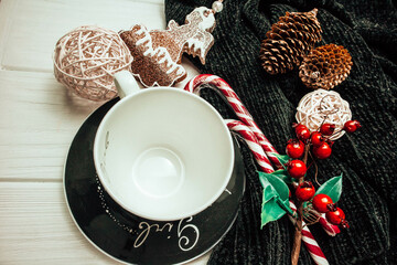 Empty cup on a saucer with christmas decoration on a white wood background