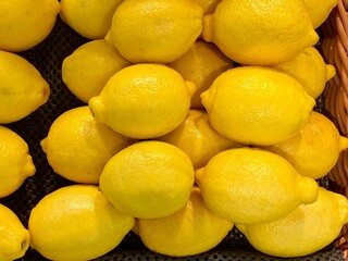 Close-up photo of lemons in market. Fruits background. Texture yellow lemon. 