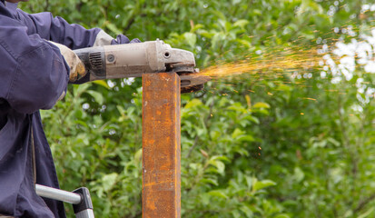 Obraz premium A worker cuts metal at a construction site. Technologies