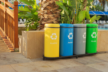 Garbage in colored trash cans with sorted garbage vector icons. (plastic, paper, metal, glass)....