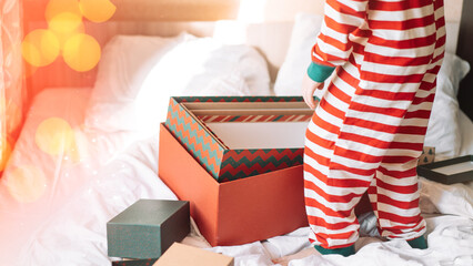 Child in striped pajamas standing next to open boxes