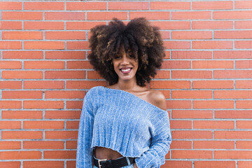 Positive african american woman with white perfect smile, long afro hair, glamour makeup and blue...