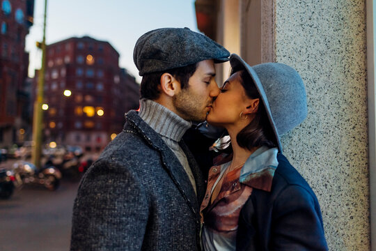 Young affectionate couple kissing with eyes closed in city