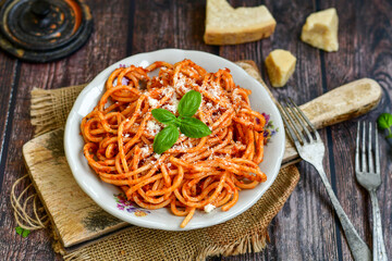 Spaghetti  bolognese .Italian home made meal Fresh  bucatini pasta with tomato sauce, basil, herbs ,parmesan cheese ,fresh cherry tomatoes and parsley on wooden background. Kitchen Poster 