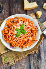 Spaghetti  bolognese .Italian home made meal Fresh  bucatini pasta with tomato sauce, basil, herbs ,parmesan cheese ,fresh cherry tomatoes and parsley on wooden background. Kitchen Poster 