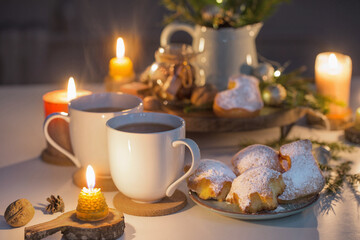 two cups of tea with homemade christmas baked goods on kitchen with christmas decoration