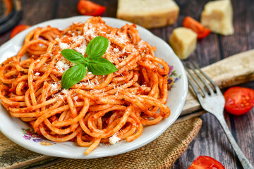 Spaghetti  bolognese .Italian home made meal Fresh  bucatini pasta with tomato sauce, basil, herbs ,parmesan cheese ,fresh cherry tomatoes and parsley on wooden background. Kitchen Poster 