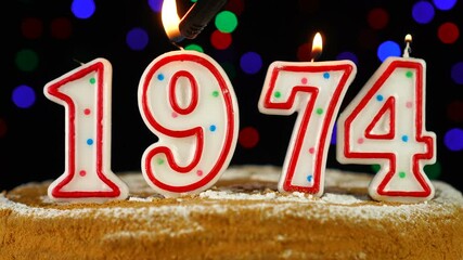 Birthday cake with white burning candles in the form of number 1974
