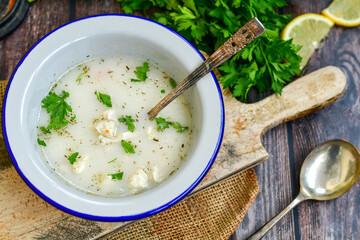 Home made chicken soup with noodles ,parsley and vegetables in white bowl . Healty soup