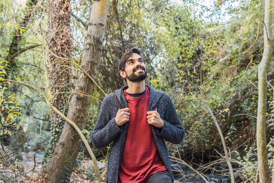 Smiling young man hiking in forest