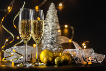 Two glasses of champagne or wine with bokeh background with christmas ball and tree