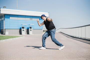 Fototapeta na wymiar athletic young guy dancing hip-hop outdoors in the street