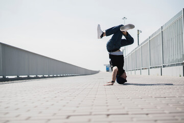 young male person doing headstand outdoors