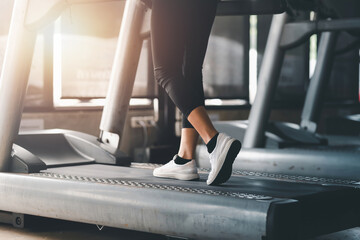 Fototapeta na wymiar Close up. Woman running in machine treadmill at fitness gym club.