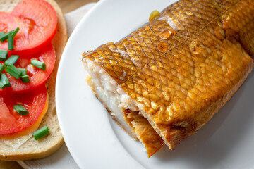 Smoked whitefish on a plate with tomato sandwich