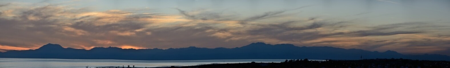 Panoramic sunset photo against the background of mountains and evening sky