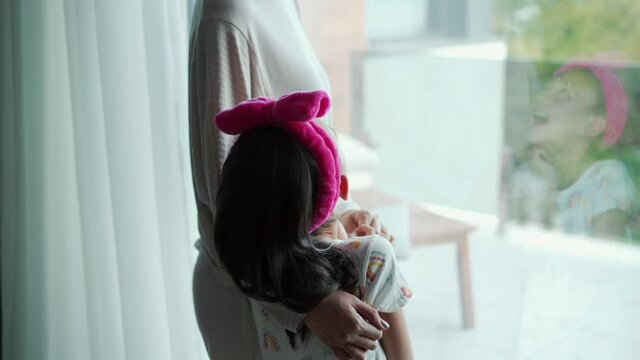 The girl laughs at the tickles of her mother in room