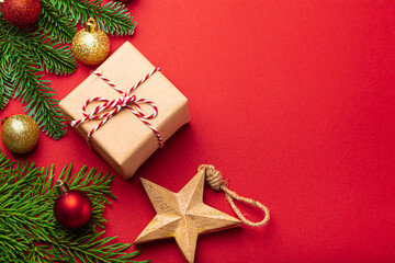 Fototapeta na wymiar Christmas decorations, fir tree, present on red background copy space