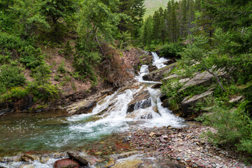 View of Wilbur Creek Falls at Swiftcurrent and Many Glacier in Glacier National Park in Montana in...