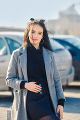 Obraz premium Young woman posing at the parking near the mall