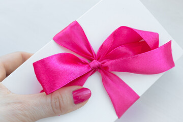 Gift for a girl. Valentine's Day. White box with a red bow. Scarlet ribbon. Festive surprise. Romantic postcard. Declaration of love. What women love. Positive emotions. What to gift.
