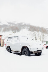 White 4x4 off-road car with all terrain wheels covered in snow. winter concept