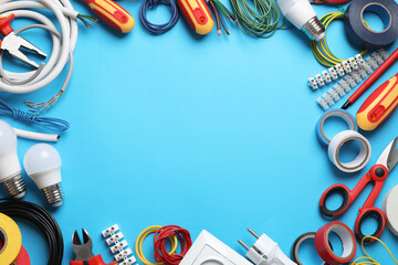 Frame of electrician's tools and accessories on light blue background, flat lay. Space for text