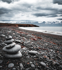 Stack of grey stones in perfect equilibrium at a beach in a northern sea in Iceland. Meditation, relax, calm