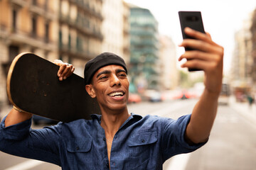 African man with skateboard. Young handsome man taking selfie photo..