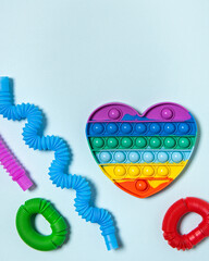 Flat lay with colorful antistress children toys on blue paper background