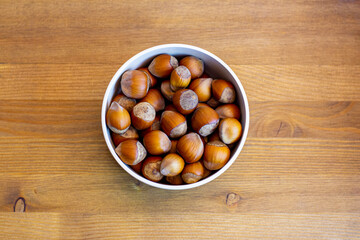 Obraz premium Hazelnuts in the bowl on wooden table