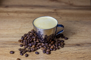 Metal cup with fresh coffee. Coffee beans around