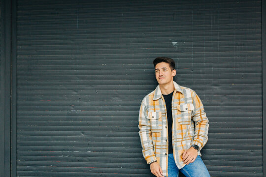 Stylish man standing against wall