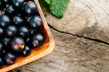 Fresh black currant. A handful of berries on a wooden table