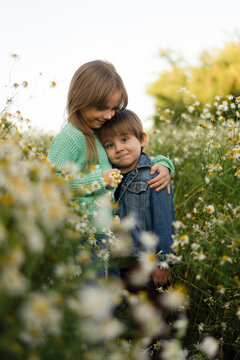 Cute siblings standing together in meadow