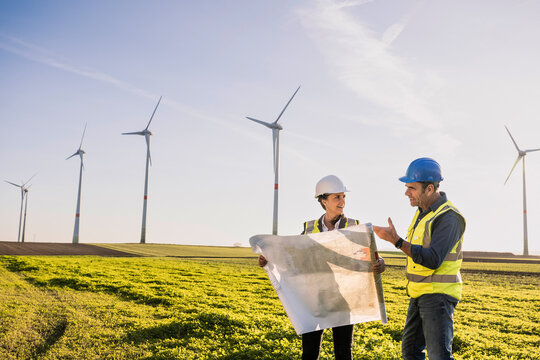 Engineer explaining business plan to colleague on sunny day
