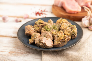 Stewed turkey fillet with garlic on white wooden background. side view, selective focus.