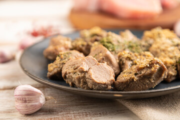 Stewed turkey fillet with garlic on white wooden background. side view, selective focus.