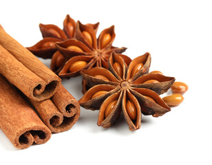 Dry anise stars and cinnamon sticks on white background, closeup