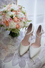 Bridal bouquet, bride shoes and earings on chair, copy space. Luxury wedding accessories and jewelry. Wedding concept